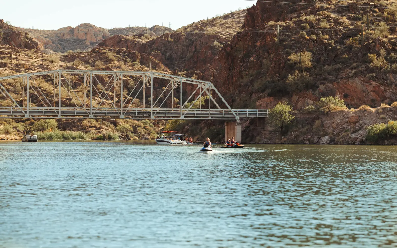 Wide view of Canyon Lake and the steel bridge with a jet ski on the water
