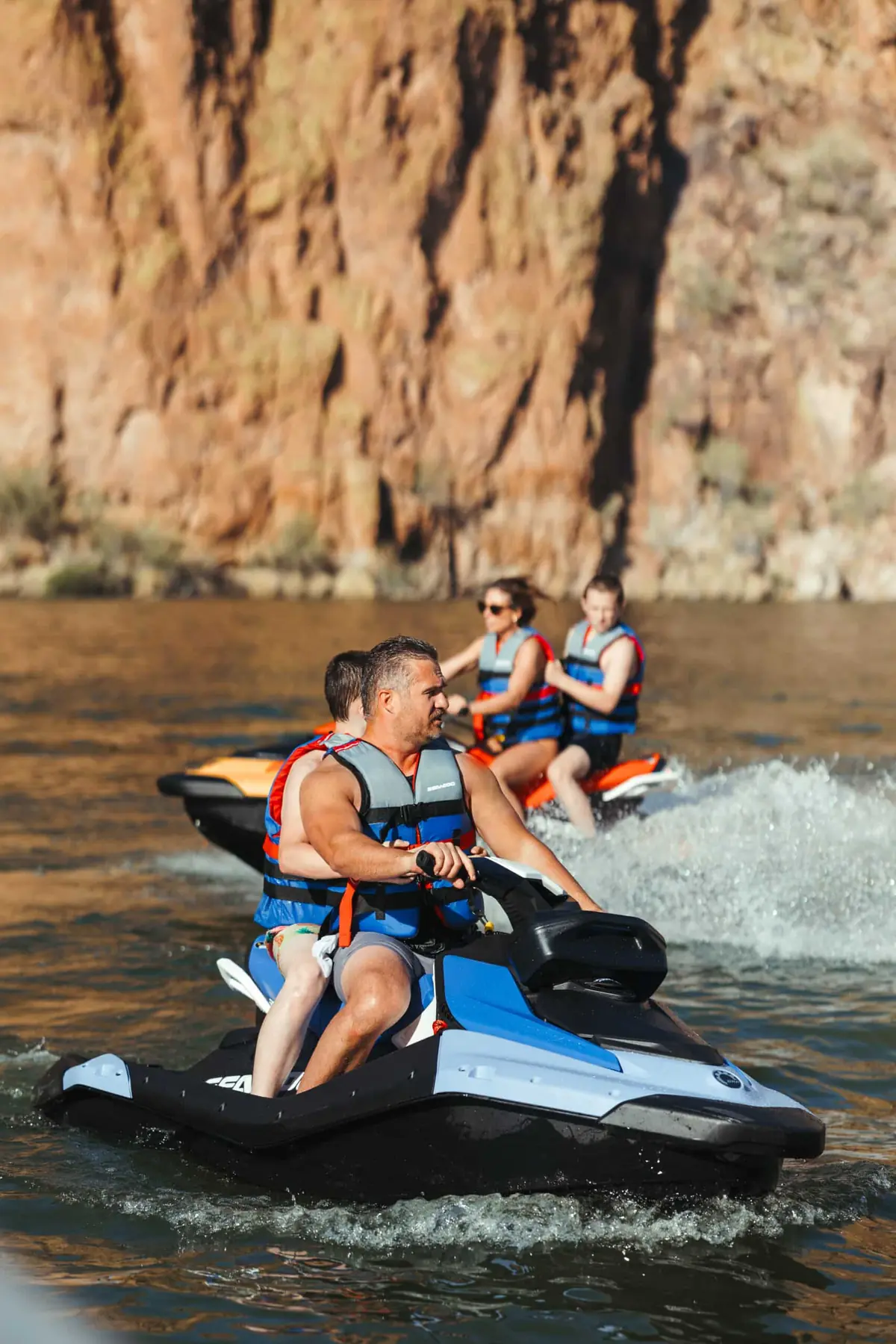 First-time riders in life vests on a blue Sea-Doo Spark jet ski