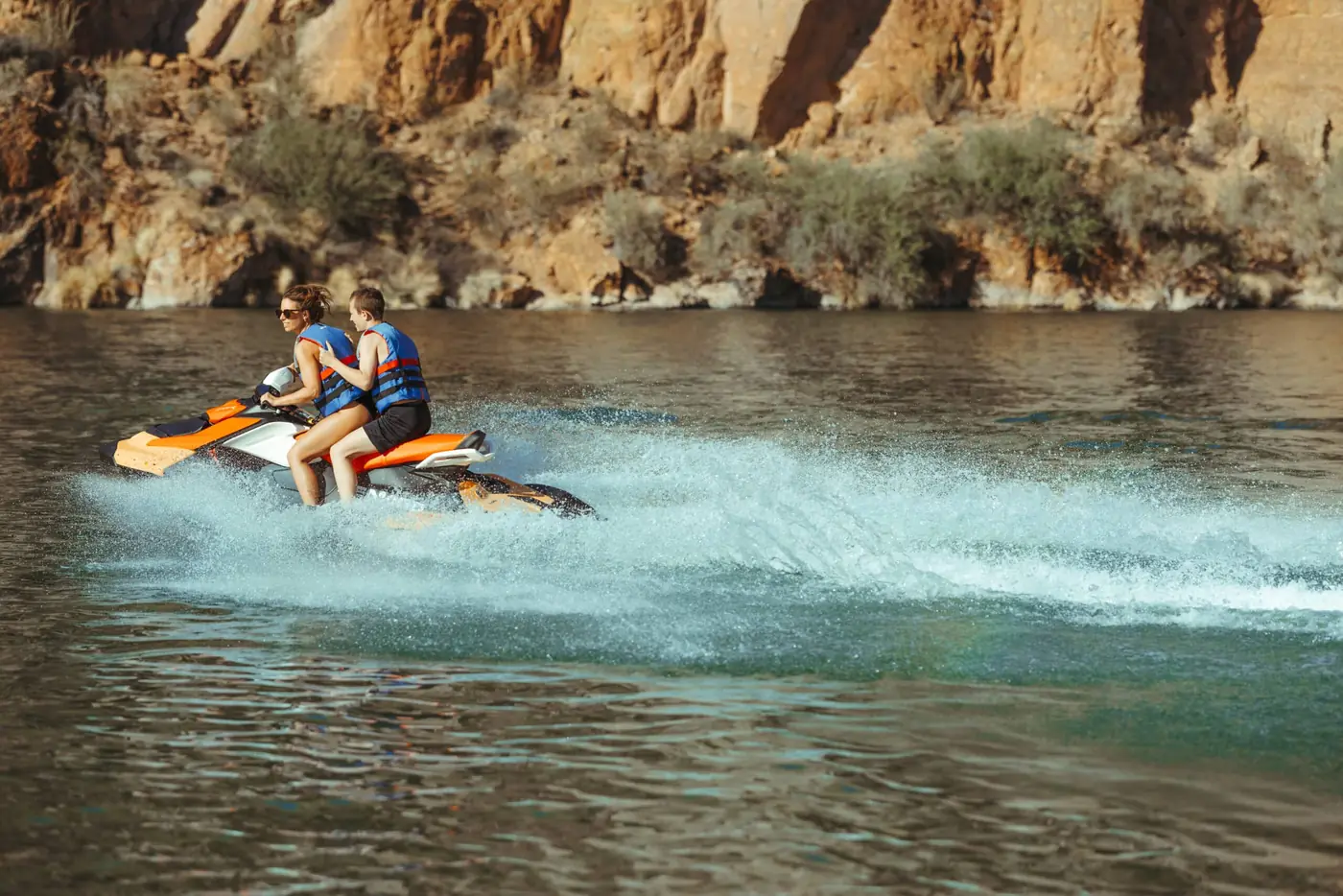 Single rider on a jet ski rental with canyon cliffs behind